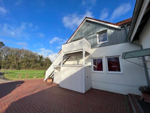 une maison blanche avec un escalier sur son côté dans l'établissement Etzhorner Tied 2, à Oldenbourg