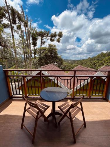 a table and two chairs sitting on a balcony at Pousada Cantinho da Serra in Campos do Jordão