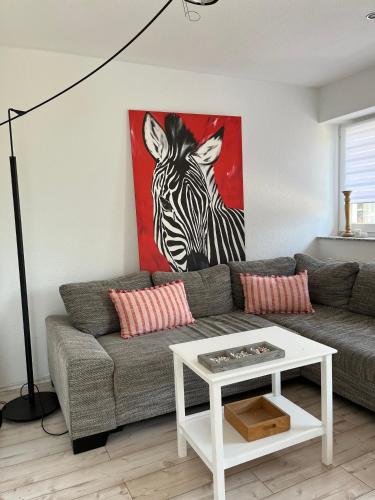 a living room with a couch and a painting of a zebra at Erlebnishof Schwanewede in Schwanewede