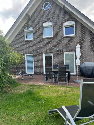 a house with chairs and a table in front of it at Erlebnishof Schwanewede in Schwanewede