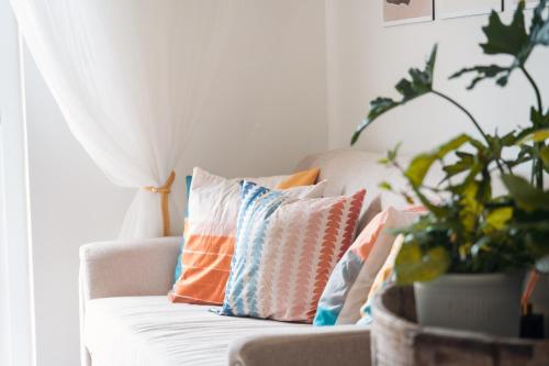 a living room with a couch with pillows and a plant at Highland Stays at Mines View in Baguio