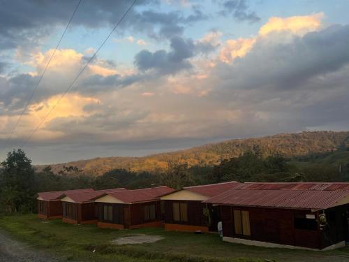 a row of cottages on a hill with a sky at Cabañas venado in Venado