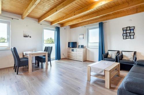 a living room with a table and a couch at Ferienwohnung Wattenmeer für 2 Personen am Badesee Tannenhausen in Aurich
