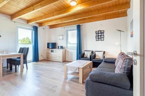 a living room with a couch and a table at Ferienwohnung Wattenmeer für 2 Personen am Badesee Tannenhausen in Aurich