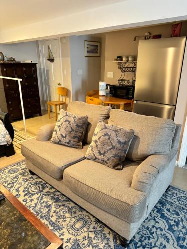 a living room with a couch and a refrigerator at Fresh Meadow Cozy Studio in Utopia