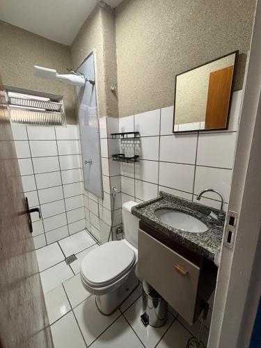 a bathroom with a toilet and a sink at Apartamento completo Corumbá in Corumbá