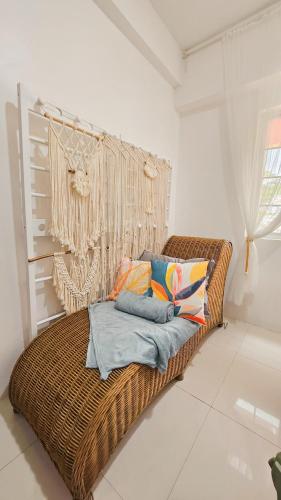 a rattan bed with pillows on it in a room at Highland Stays at Mines View in Baguio