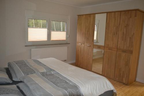 a bedroom with a bed and a large wooden cabinet at Ferienhof Thele Wohnung EG in Werlte