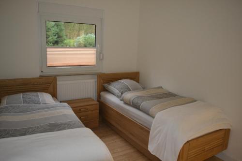 two beds in a room with a window at Ferienhof Thele Wohnung EG in Werlte
