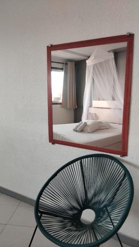 a mirror reflecting a bedroom with a bed and a fan at Residence de la baie in Lazaret
