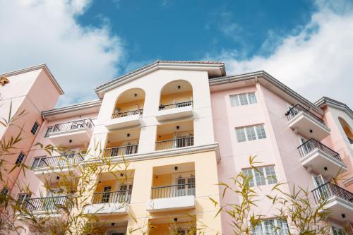 a pink building with balconies and trees at Highland Stays at Mines View in Baguio