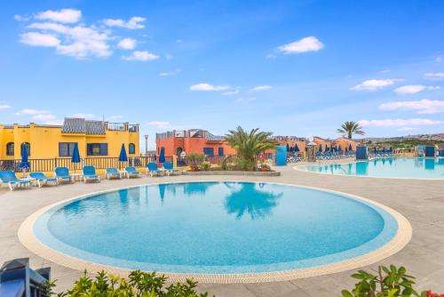 una piscina en el complejo con sillas y mesas en Playa de las Mujeres, en San Bartolomé