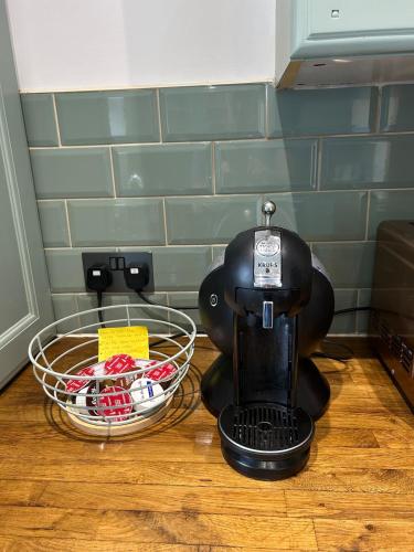a coffee maker sitting on top of a table at The Little Green Cosy Cottage in Bury
