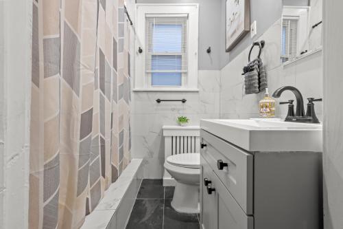 a bathroom with a white toilet and a sink at 2-Story Stay with Game Lounge & Free Parking Spots - 5 mins to NYC Train in Linden