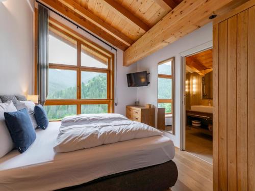 a bedroom with a large bed and a bathroom at Chalet Huski Viehhofen in Saalbach Hinterglemm