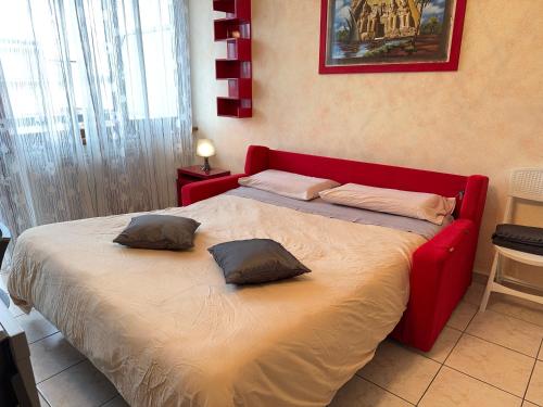 a bedroom with a red bed with two pillows on it at Private Garage, 300m from Sea in Alassio Centre in Alassio