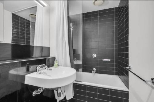 y baño en blanco y negro con lavabo y bañera. en Private Room in the Heart of Melbourne 1 Min to Southern Cross Station, en Melbourne