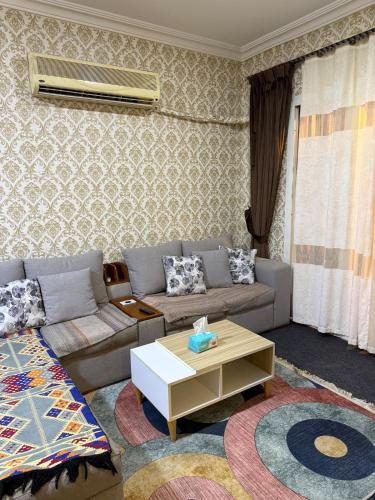 a living room with a couch and a coffee table at Elegant apartment with garden in Sheikh Zayed