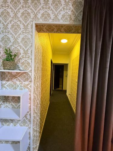 a hallway with a mirror and a curtain at Elegant apartment with garden in Sheikh Zayed