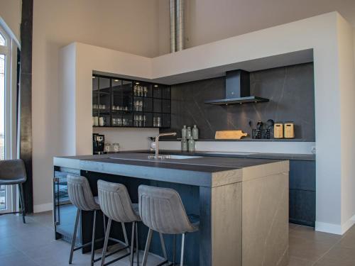a kitchen with a large blue island with stools at Jonkershof in Zevenhuizen