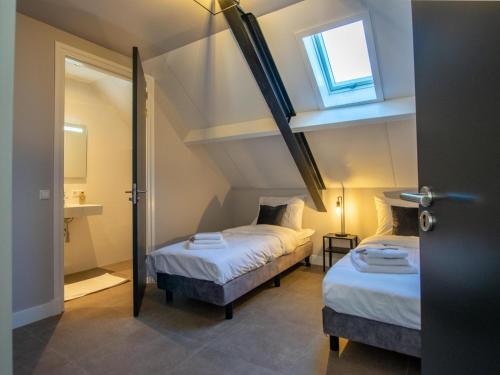 two beds in a small room with a window at Jonkershof in Zevenhuizen