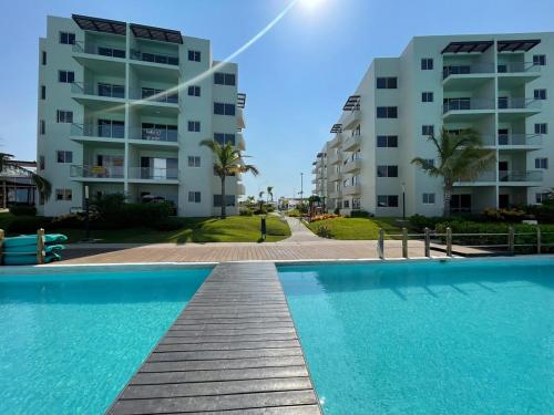 ein Swimmingpool vor zwei Wohnhäusern in der Unterkunft Te Va a Encantar, Torre Turquesa in Mazatlán