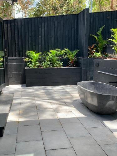 a large stone tub sitting on a patio at Jezabel's Retreat Jervis Bay in Vincentia