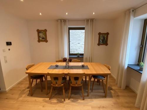 a dining room with a wooden table and chairs at Holiday home with 4 rooms and terrace in Osann-Monzel