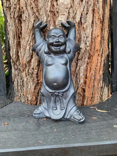 a statue of a child sitting in front of a tree at Jezabel's Retreat Jervis Bay in Vincentia