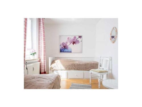 a white bedroom with a bed and a table at Perennial in the aft deck Comfortable holiday residence in Travemünde