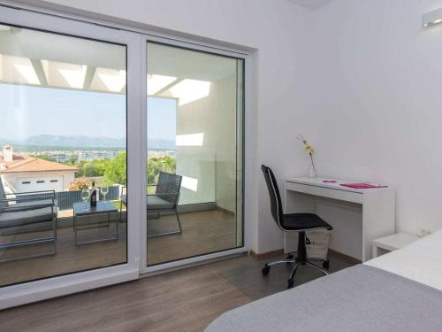 a bedroom with a bed and a desk and a window at Villa with sea view Comfortable holiday residence in Malinska