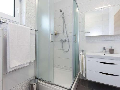 a bathroom with a glass shower and a sink at Villa with sea view Comfortable holiday residence in Malinska