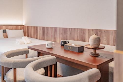 a room with a table with two chairs and a bed at Apartment Hotel 11 Kuromon 4 in Osaka