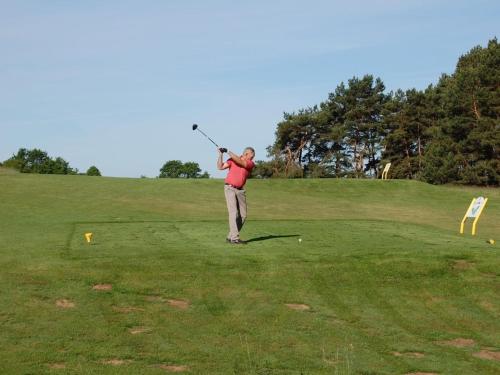 a man swinging a golf club on a golf course at Holiday home Usedom Residenz Balmer See Kümpel in Balm
