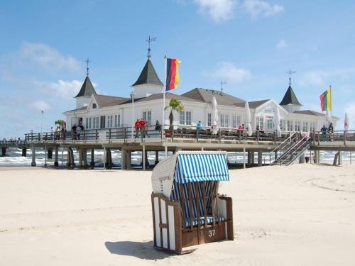 a chair sitting on the beach next to a pier at Holiday home Usedom Residenz Balmer See Kümpel in Balm