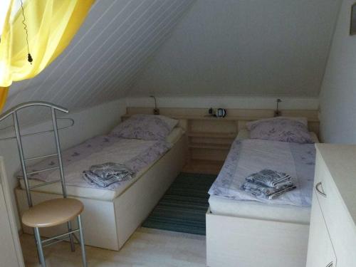 a room with two beds and a chair in a attic at Holiday apartment in Wiek with 1 room in Wiek auf Rügen 