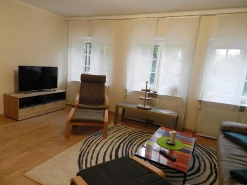 a living room with a couch and a tv at Garden view Comfortable holiday residence in Westerstede