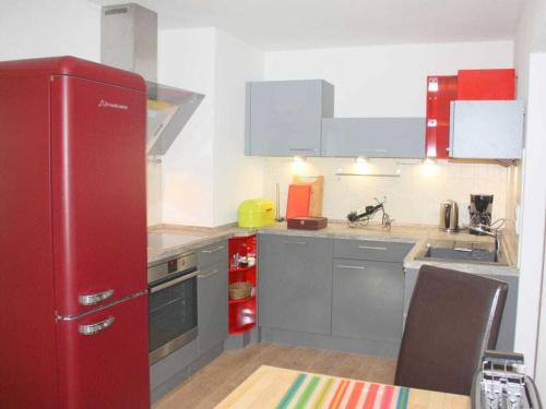 a kitchen with a red refrigerator and a sink at Garden view Comfortable holiday residence in Westerstede