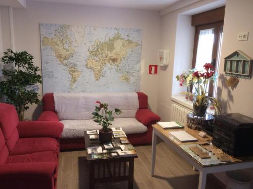 a living room with a couch and a map on the wall at La Casa de los Soportales in Mansilla de las Mulas