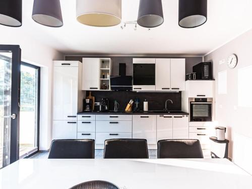 a kitchen with white cabinets and black appliances at Lagunenhaus Joy Comfortable holiday residence in Kahnsdorf