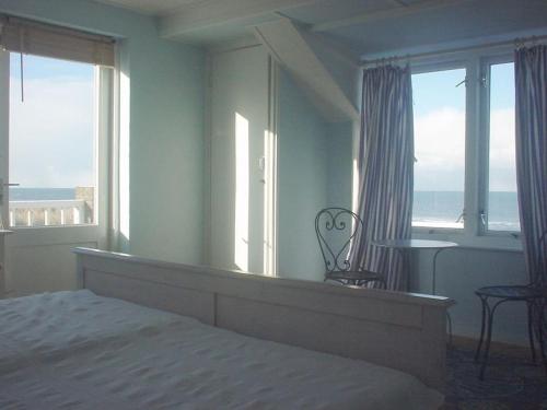 a bedroom with a bed and a view of the ocean at Pacific Ocean View Comfortable Holiday Residence in Bergen aan Zee