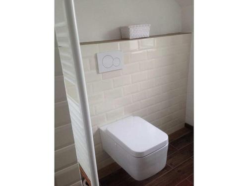 a white toilet in a bathroom with a white tile wall at Pacific Ocean View Comfortable Holiday Residence in Bergen aan Zee