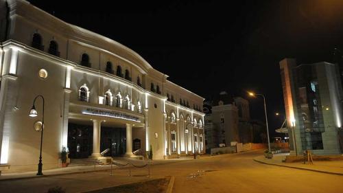 a large building with lights on a street at night at LION Apartments - DEBAR MAALO in Skopje
