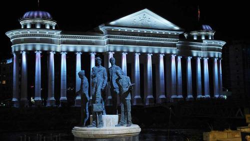 a statue of three people in front of a building at LION Apartments - DEBAR MAALO in Skopje