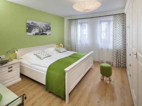 ein grünes Schlafzimmer mit einem großen Bett und einem Stuhl in der Unterkunft Bergwiese Comfortable holiday residence in Oberstaufen