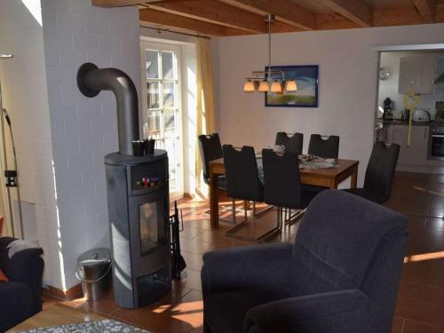 a living room with a wood stove and a dining room at Captain's cabin Comfortable holiday residence in Greetsiel