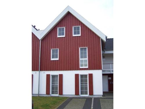 a red and white house with white trim at Captain's cabin Comfortable holiday residence in Greetsiel