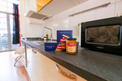 a kitchen counter with a microwave and some food on it at casa dolce casa in Rome