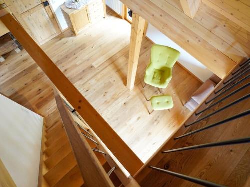 Cette chambre offre une vue de tête sur le parquet et dispose d'une chaise verte. dans l'établissement Heimatglück Comfortable holiday residence, à Lautenbach