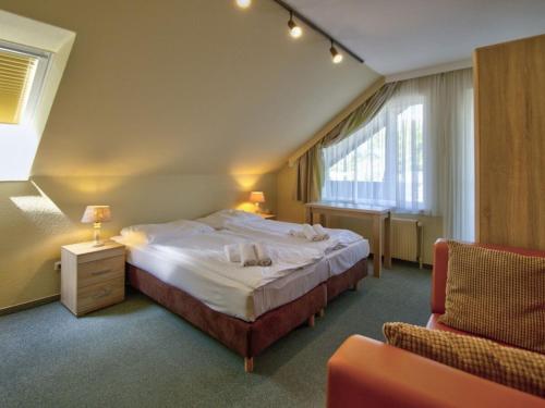 a hotel room with a bed and a chair at Holiday apartment F995 at Wulfener Hals, Fehmarn in Wulfen auf Fehmarn